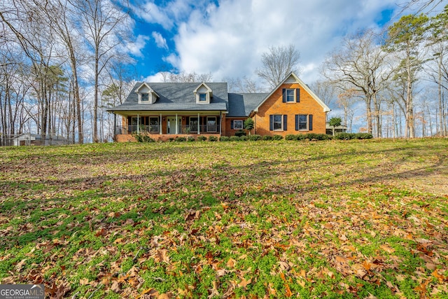 new england style home featuring a sunroom and a front lawn