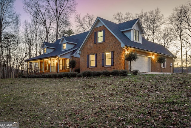 exterior space featuring a garage, a porch, and brick siding