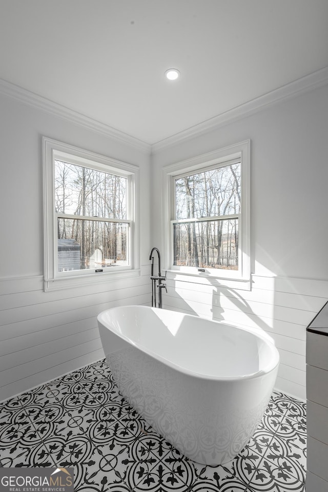 bathroom with tile patterned floors, a wealth of natural light, and a bathtub