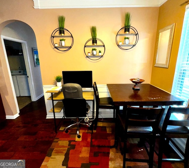 dining room featuring arched walkways and baseboards