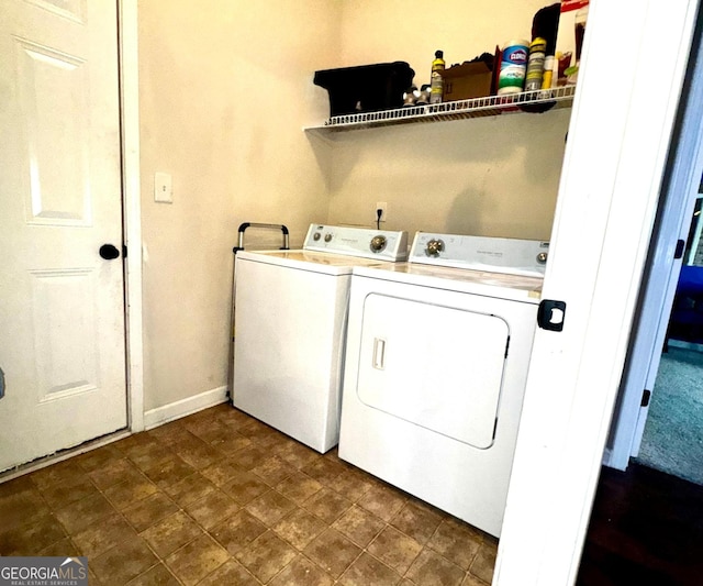 washroom featuring laundry area, separate washer and dryer, and baseboards