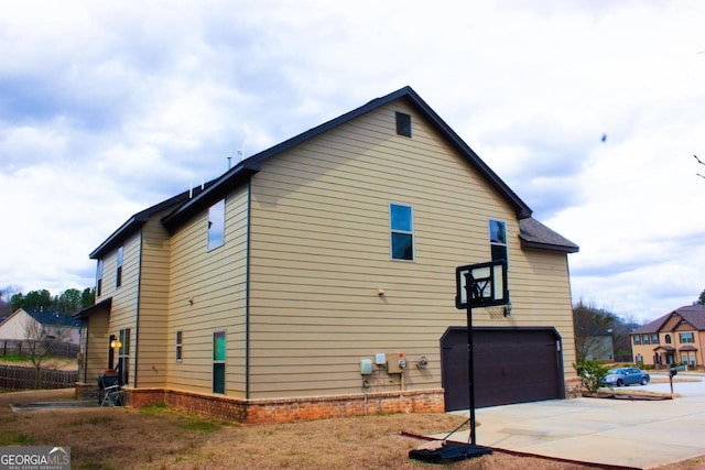 view of side of home with brick siding, concrete driveway, and a garage