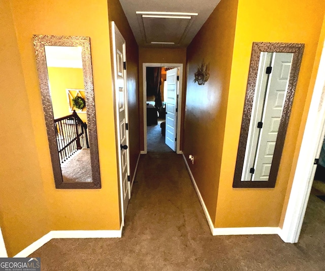 hallway with baseboards and dark carpet