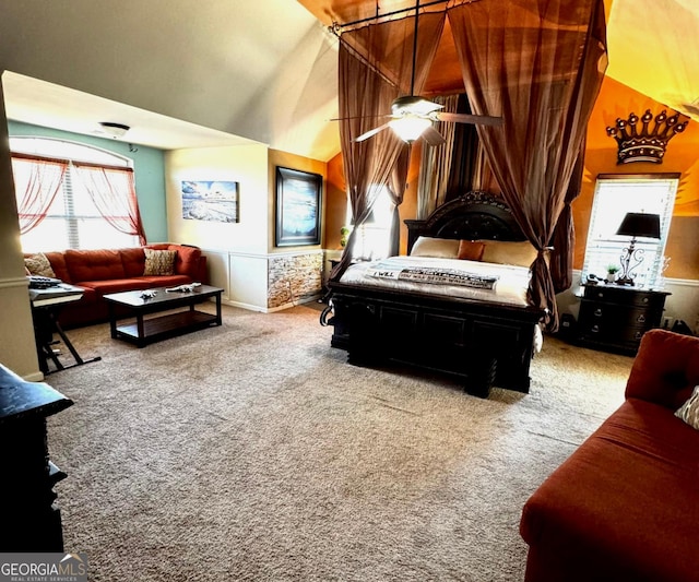 bedroom with lofted ceiling, carpet floors, and wainscoting