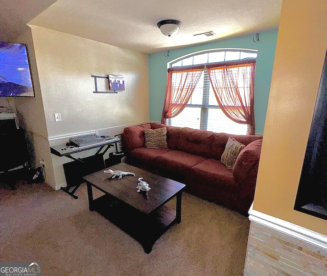 living area with visible vents and a textured ceiling