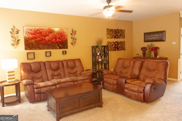 living area with baseboards, light carpet, and a ceiling fan