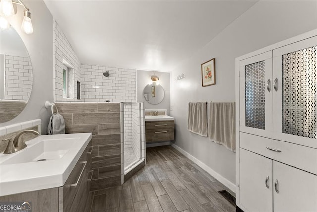 bathroom with a tile shower, vanity, and hardwood / wood-style flooring