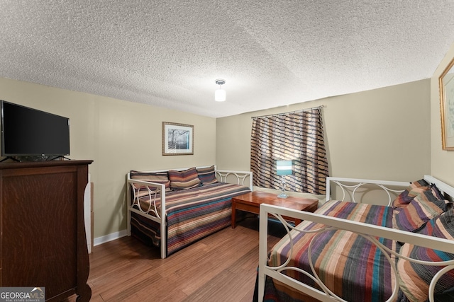 bedroom with hardwood / wood-style floors and a textured ceiling