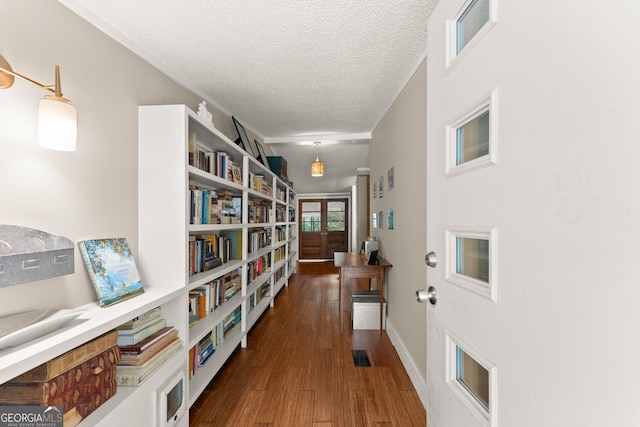 corridor with dark hardwood / wood-style flooring and a textured ceiling