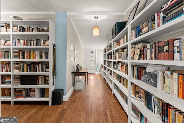 hall featuring hardwood / wood-style flooring and a textured ceiling