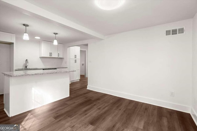 kitchen featuring light stone countertops, dark hardwood / wood-style flooring, white cabinets, and hanging light fixtures