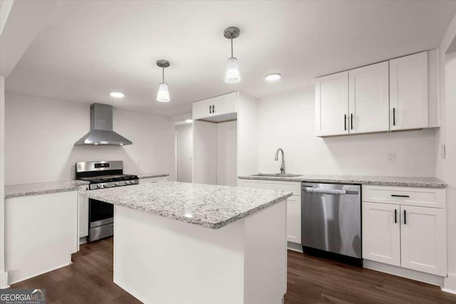 kitchen featuring white cabinets, wall chimney exhaust hood, sink, and appliances with stainless steel finishes