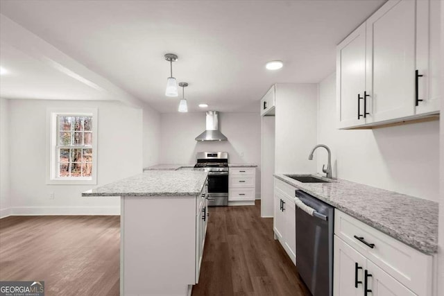 kitchen with appliances with stainless steel finishes, light stone counters, wall chimney range hood, sink, and white cabinetry