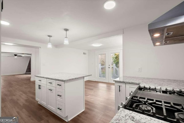 kitchen featuring hanging light fixtures, ceiling fan, light stone countertops, dark hardwood / wood-style flooring, and white cabinetry