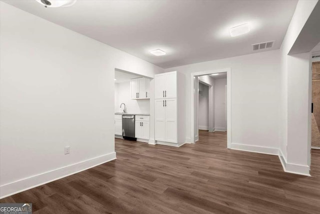 unfurnished living room with dark hardwood / wood-style flooring and sink