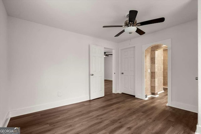 unfurnished bedroom with dark hardwood / wood-style flooring, connected bathroom, and ceiling fan