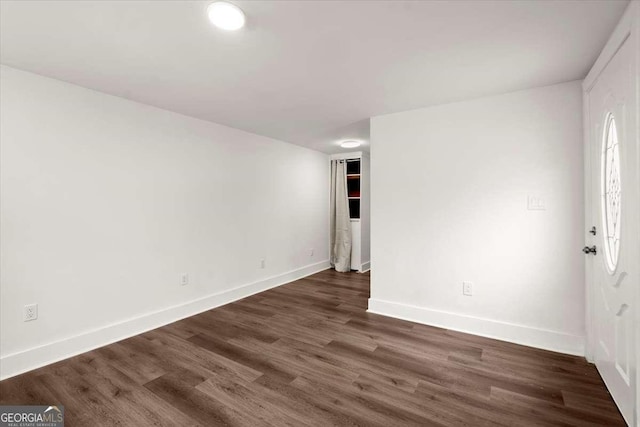 unfurnished room with dark wood-type flooring