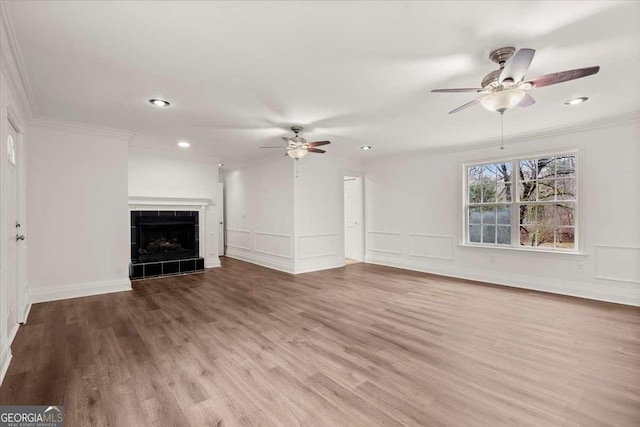 unfurnished living room featuring a tile fireplace, light hardwood / wood-style floors, and crown molding