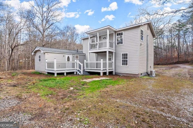 back of house with a balcony and a wooden deck