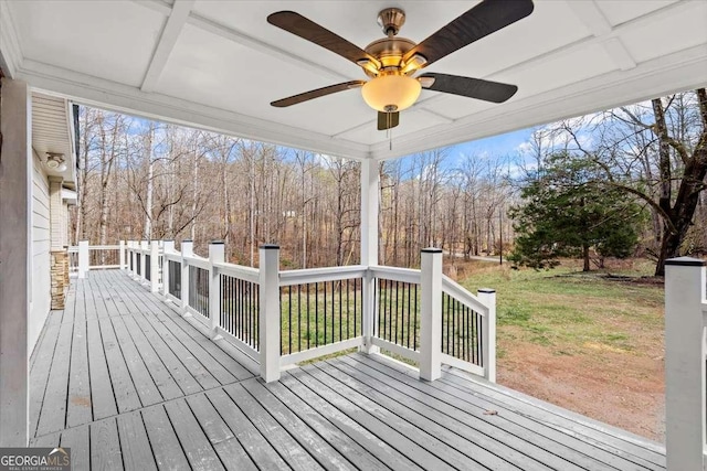 wooden deck featuring ceiling fan and a yard