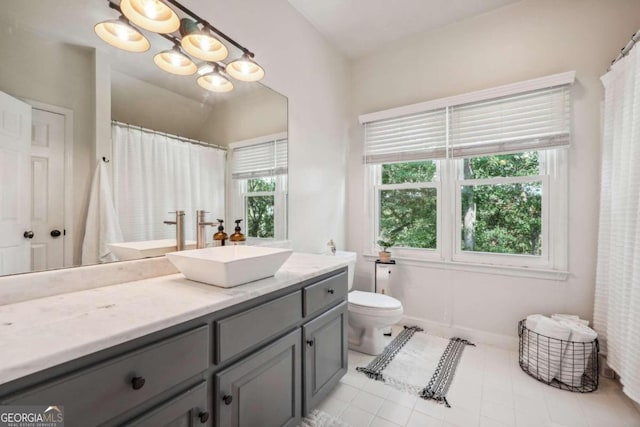 bathroom with toilet, tile patterned floors, vanity, and vaulted ceiling