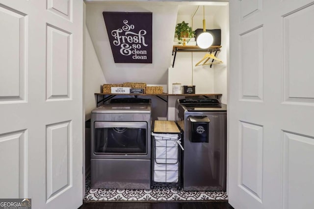 washroom with washer and dryer and dark wood-type flooring