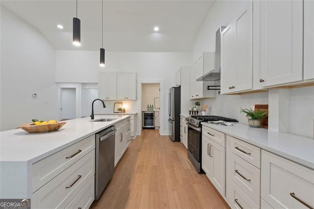 kitchen with light countertops, appliances with stainless steel finishes, decorative light fixtures, and white cabinets