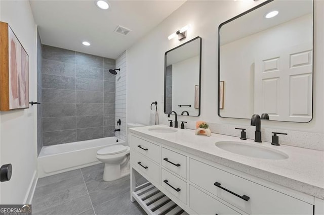 full bathroom featuring tiled shower / bath, vanity, and toilet