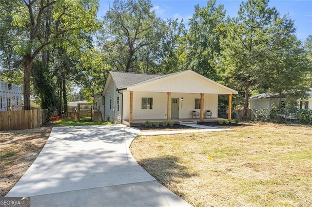 view of front facade with covered porch, fence, and a front lawn