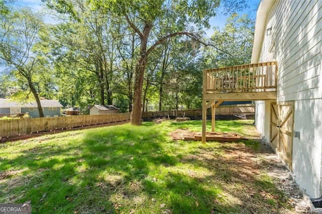 view of yard with a fenced backyard and a wooden deck