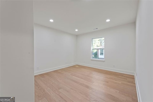 spare room with light wood finished floors, baseboards, and recessed lighting