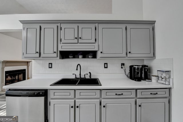 kitchen with decorative backsplash, stainless steel dishwasher, gray cabinetry, and sink