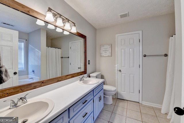 bathroom featuring tile patterned floors, vanity, toilet, and a textured ceiling