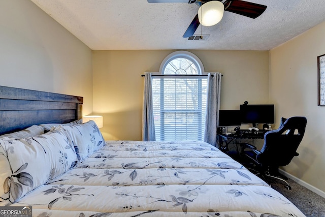 carpeted bedroom featuring a textured ceiling and ceiling fan