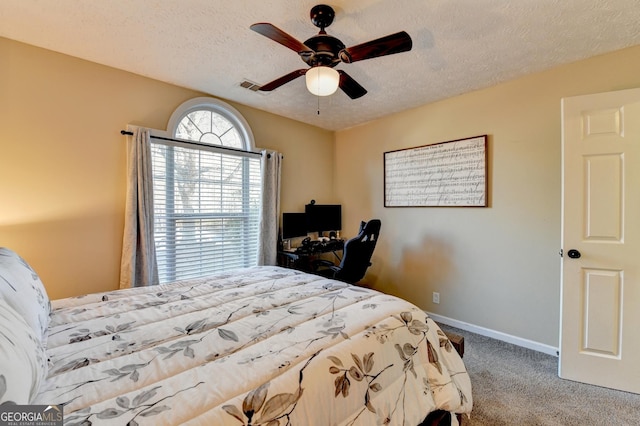 bedroom featuring carpet flooring, ceiling fan, and a textured ceiling