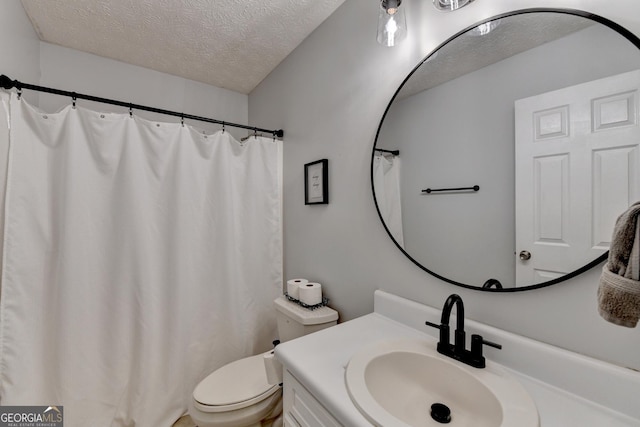 bathroom with vanity, toilet, and a textured ceiling