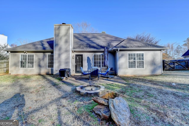 back of house featuring a fire pit, a yard, and a patio