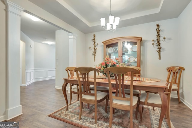 dining room with wood-type flooring, a tray ceiling, and a chandelier