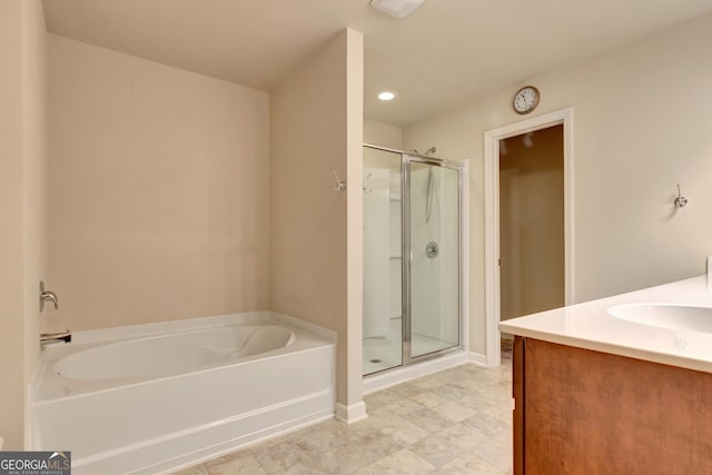 bathroom with vanity and shower with separate bathtub