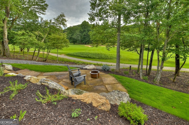 view of property's community with a lawn and a patio area