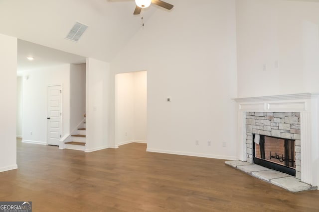 unfurnished living room featuring visible vents, a fireplace, ceiling fan, wood finished floors, and stairway