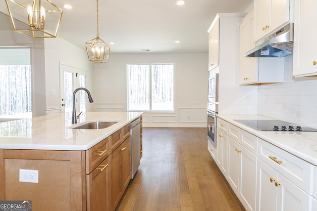 kitchen featuring light countertops, under cabinet range hood, a sink, visible vents, and appliances with stainless steel finishes