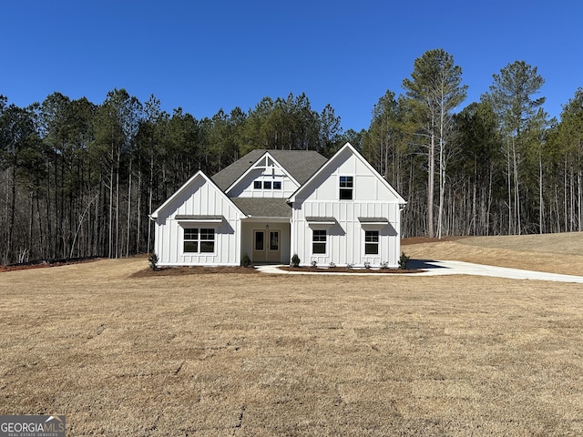 modern inspired farmhouse featuring a forest view, board and batten siding, and a front yard