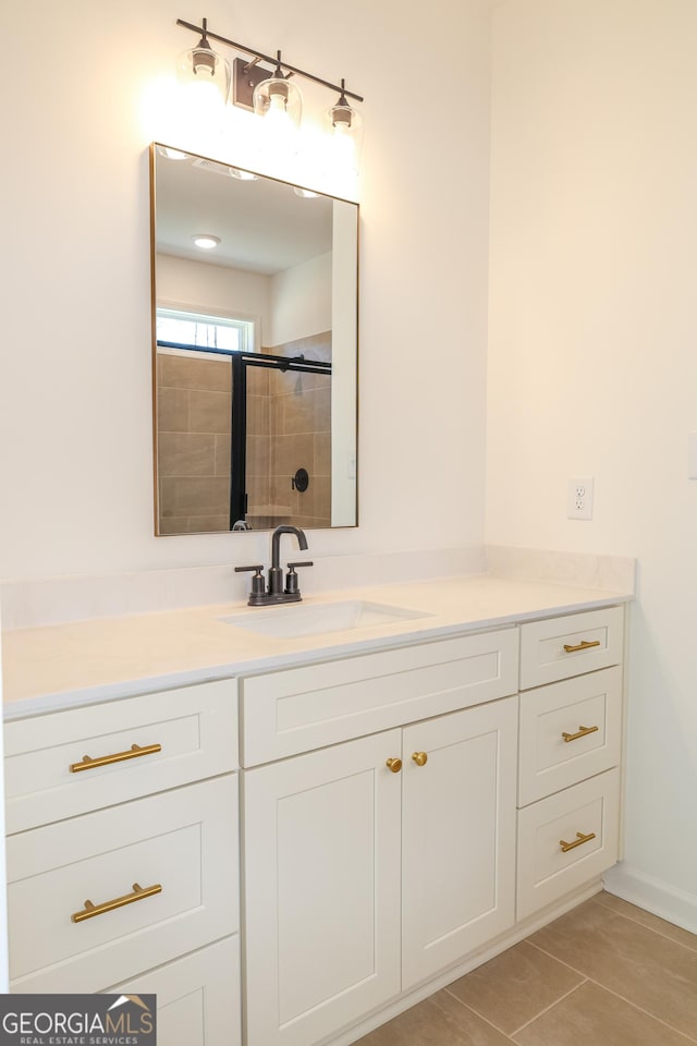 full bathroom featuring a tile shower, tile patterned flooring, and vanity