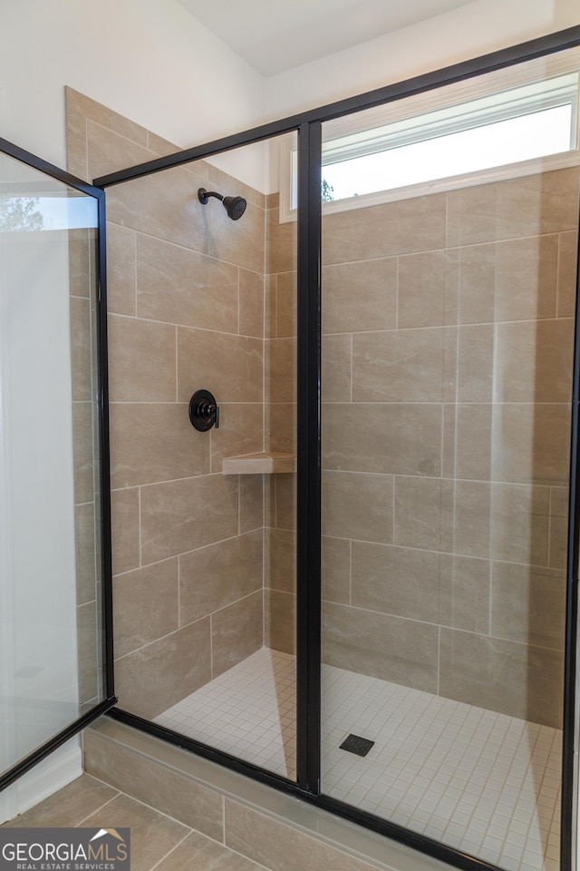 full bathroom featuring a tile shower, tile patterned flooring, and vanity