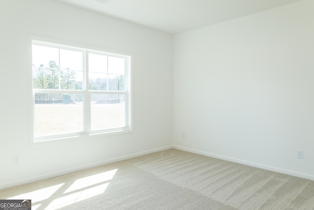 carpeted spare room featuring baseboards