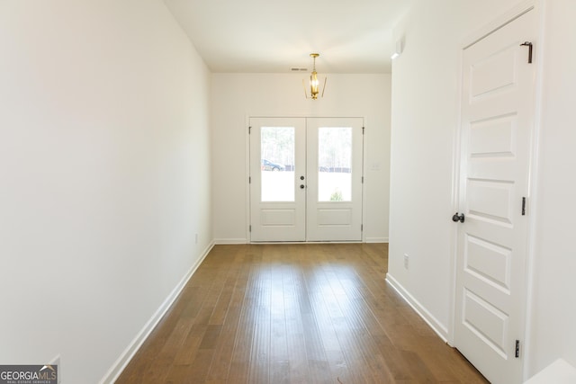 foyer featuring dark wood finished floors, baseboards, visible vents, and french doors