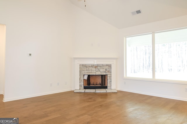 unfurnished living room with light wood finished floors, baseboards, visible vents, and a fireplace