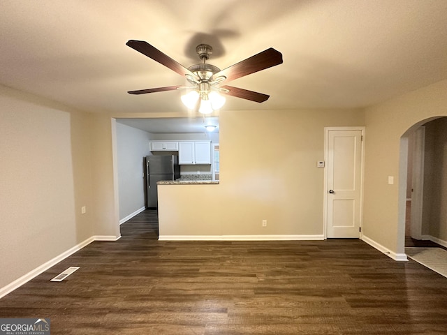 empty room with ceiling fan and dark hardwood / wood-style flooring