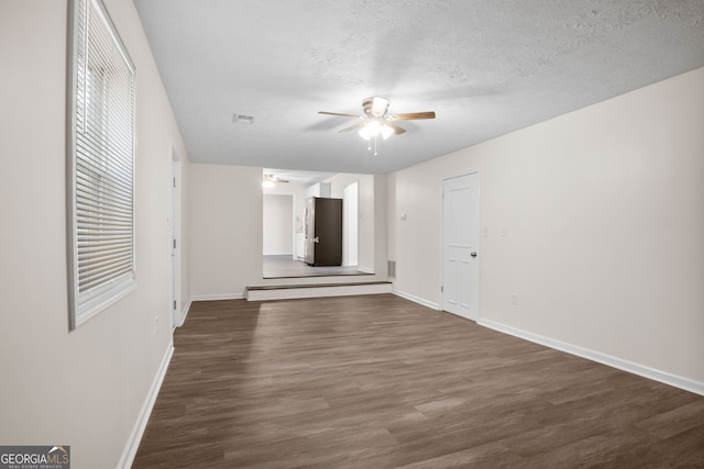 spare room with a textured ceiling, dark hardwood / wood-style flooring, and ceiling fan